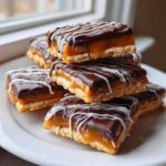 A stack of delicious caramel ritz cracker christmas cookies topped with chocolate and white drizzle.