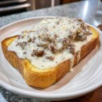 Close-up of a thick slice of buttered toast smothered in creamy chipped beef on toast gravy.