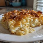 A close-up of a creamy slice of baked mac and cheese recipe with a golden, crispy topping.
