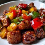 Close-up of glazed chicken pieces, pineapple chunks, and colorful bell peppers from the hawaiian chicken sheet pan.