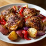 Four pieces of perfectly roasted greek chicken with crispy skin served over red potatoes, red onion, and peppers.