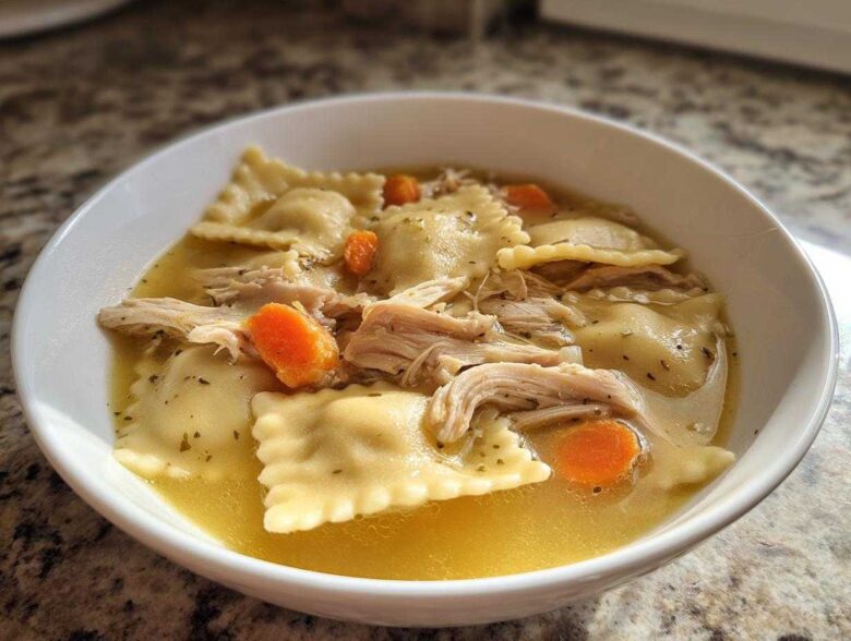 A bowl of quick chicken and dumpling soup featuring ravioli-style dumplings, shredded chicken, and sliced carrots in broth.