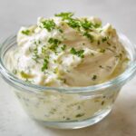 Close-up of creamy homemade tartar sauce recipe garnished with fresh chopped parsley.