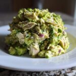 A generous mound of creamy avocado chicken salad served on a white plate.