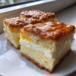 Three squares of moist bee sting cake layered with cream and topped with shiny, crunchy caramelized nuts.