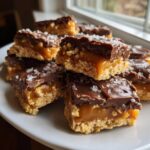 Close-up of stacked caramel ritz cracker christmas cookies topped with chocolate and sea salt.