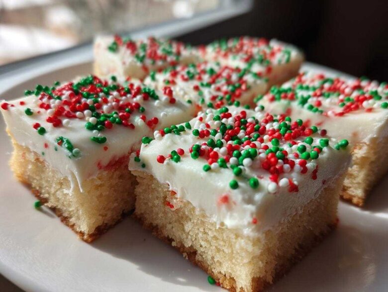 Close-up of frosted Christmas sugar cookie bars topped with red, green, and white sprinkles.