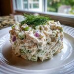 A serving of creamy cottage cheese chicken salad mixed with celery and red onion, topped with fresh dill.