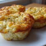 Three golden-brown cottage cheese egg cups starbucks style served on a white plate.