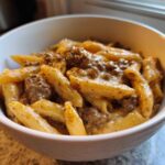 Close-up of creamy beef pasta featuring penne coated in a rich sauce with ground beef.