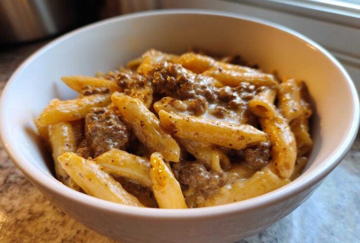 Close-up of creamy beef pasta featuring penne coated in a rich sauce with ground beef.
