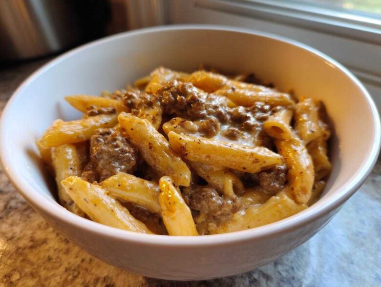 Close-up of creamy beef pasta featuring penne coated in a rich sauce with ground beef.