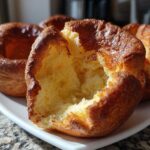 Close-up of a perfectly risen yorkshire pudding, torn open to show the fluffy, airy interior texture.
