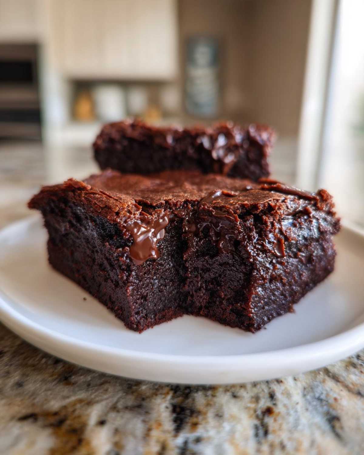 Close-up of two fudgy sweet potato brownies with melted chocolate chips served on a white plate.