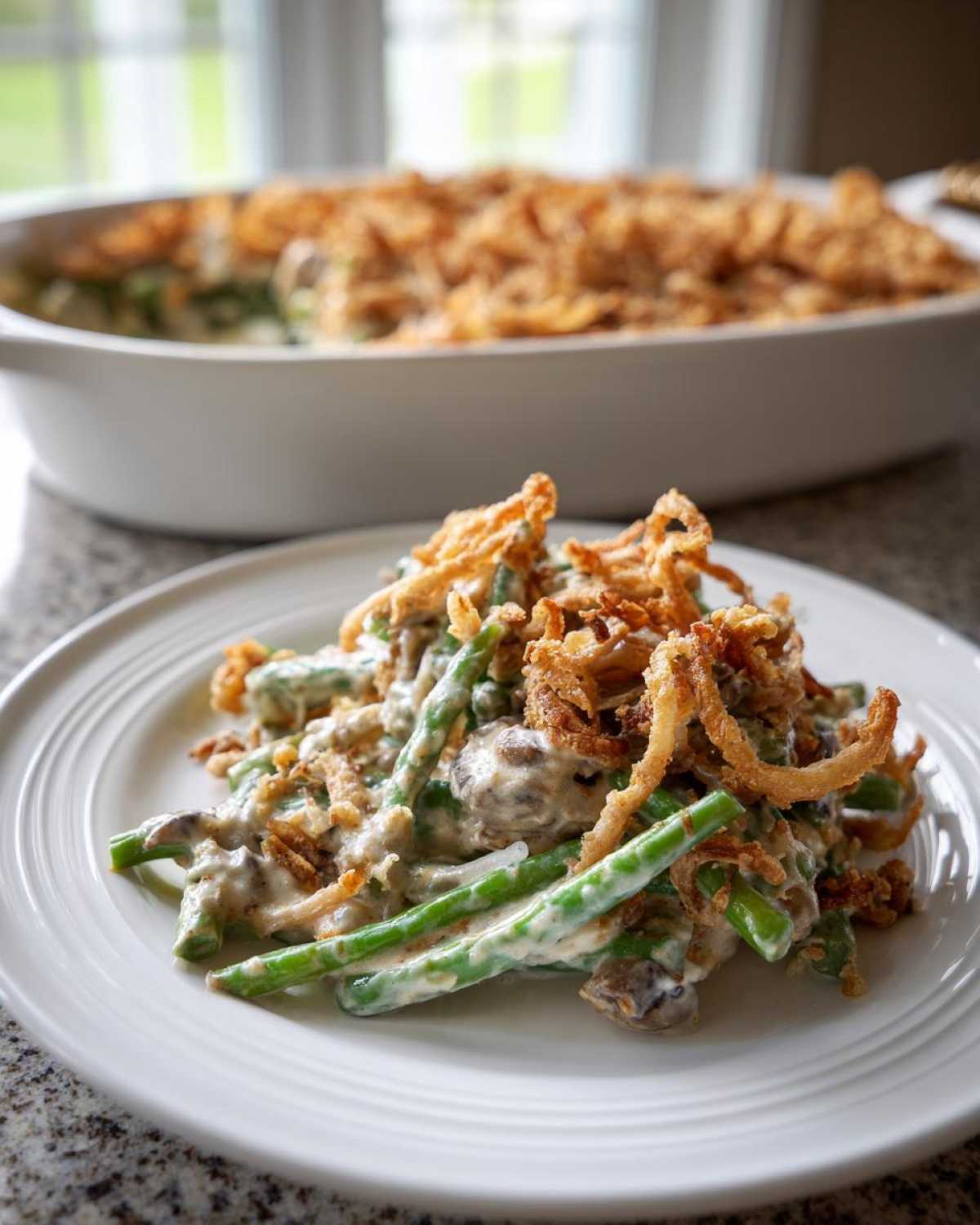 A serving of amazing green bean casserole featuring green beans in a creamy sauce, topped generously with crispy fried onions.