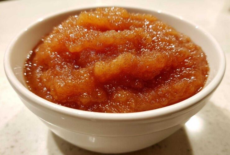 Close-up of chunky, spiced homemade applesauce served in a small white bowl.