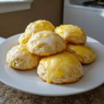A stack of soft Italian ricotta cookies topped with a bright lemon glaze and zest.