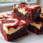 A stack of rich, fudgy red velvet cheesecake brownies featuring a vibrant red base and creamy white cheesecake swirls.
