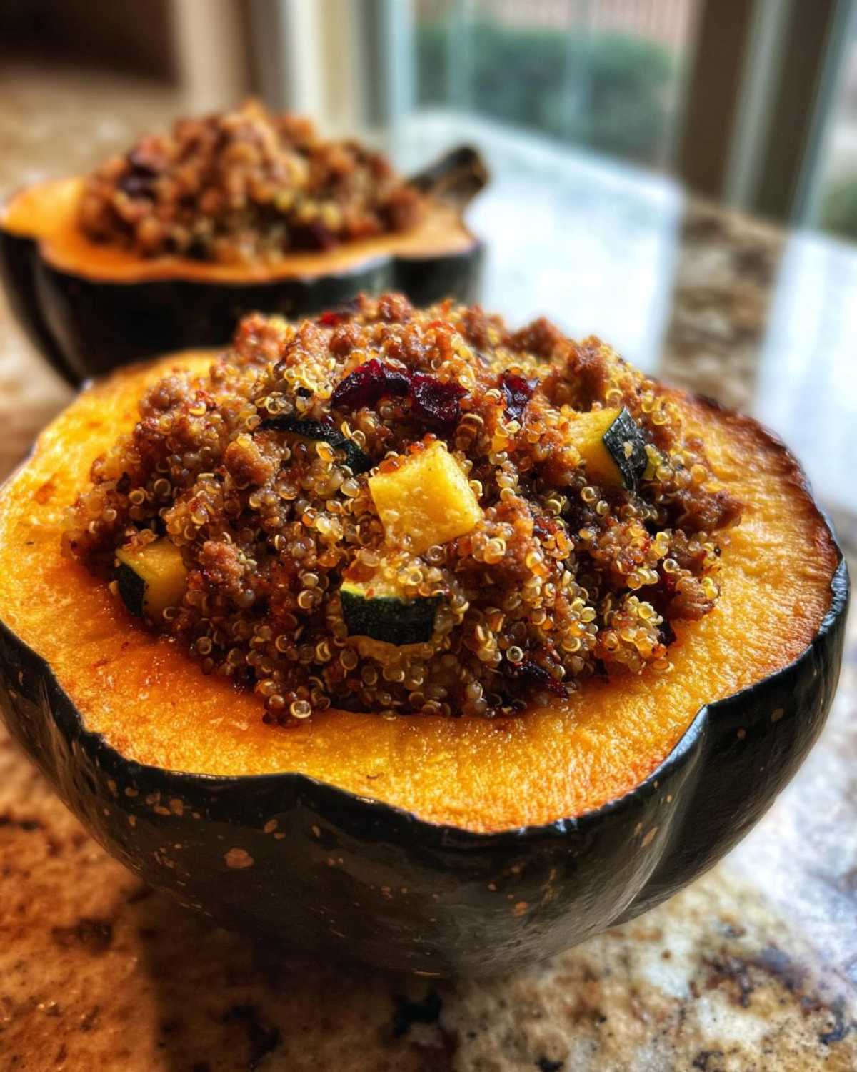 Close-up of a baked acorn squash half filled with a savory quinoa stuffing, featuring cranberries and squash pieces, perfect for stuffed acorn squash.
