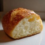 Cross-section of a sturdy bread bowl showing a golden crust and soft, airy interior crumb.