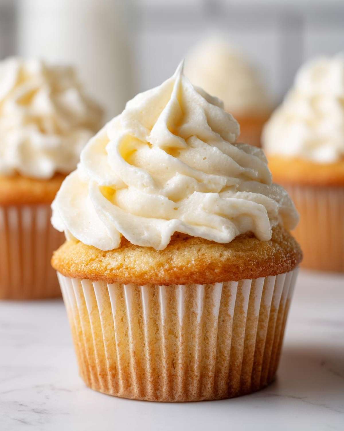 Close-up of a single, beautifully frosted vanilla cupcakes with creamy white buttercream.