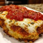 Close-up of a crispy, breaded Air Fryer Chicken Parmesan topped with melted mozzarella and marinara sauce.