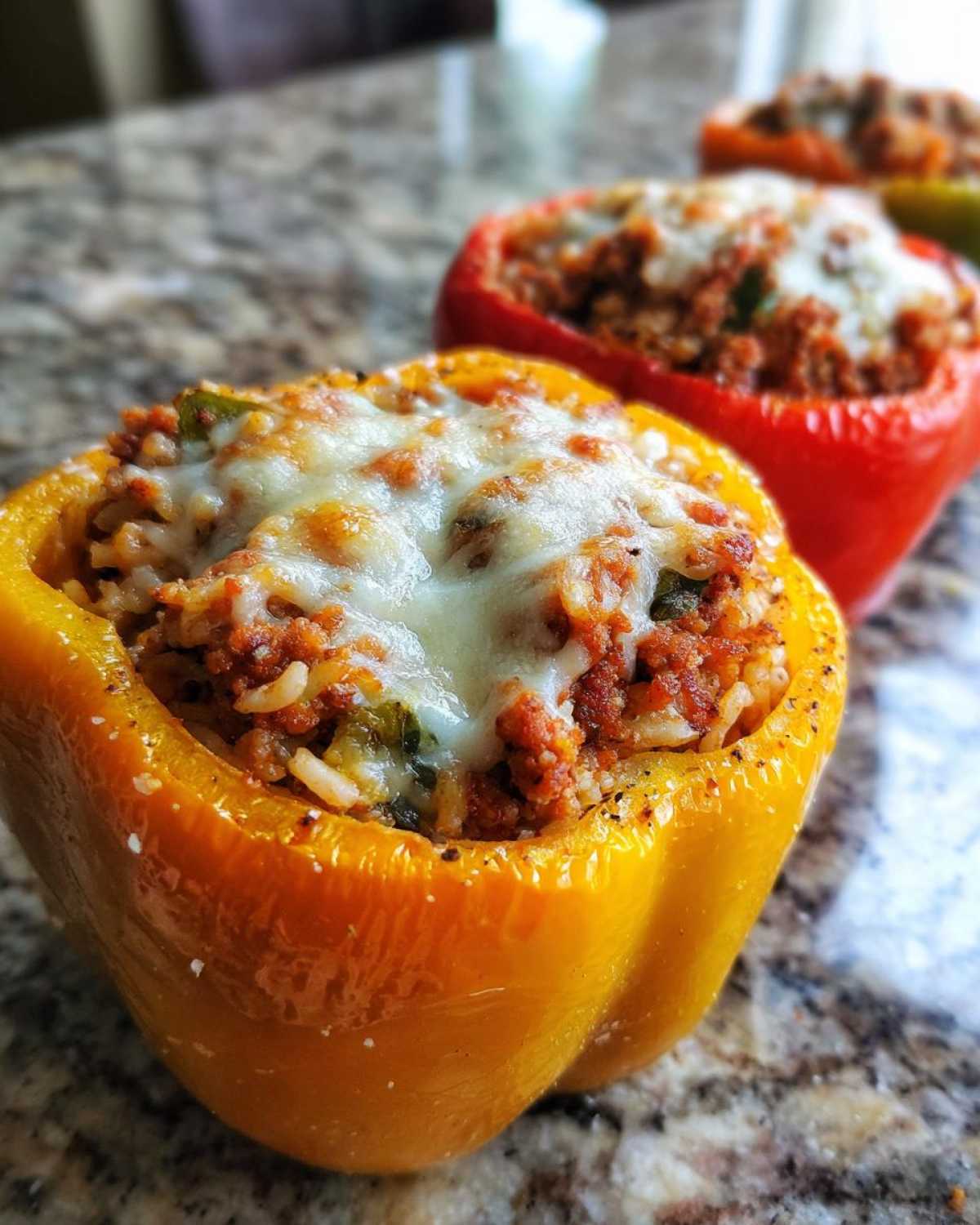 Close-up of a bright yellow Air Fryer Stuffed Bell Pepper topped with melted mozzarella cheese.