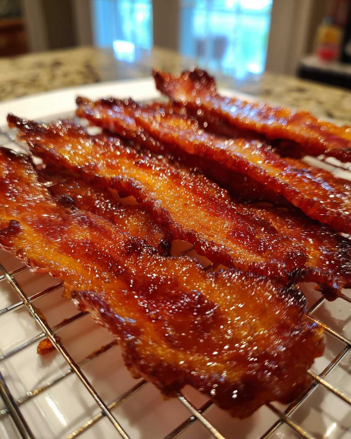 Close-up of shiny, caramelized Brown Sugar Glazed Bacon strips resting on a wire cooling rack.