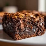 A close-up, macro shot of a rich, dark square of Chewy Chocolate Chip Cookie Bars with visible melted chocolate chips.