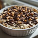 A close-up of Chocolate Peanut Butter Cheesecake Dip topped with chocolate shavings and peanut butter chips.