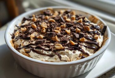 A close-up of Chocolate Peanut Butter Cheesecake Dip topped with chocolate shavings and peanut butter chips.