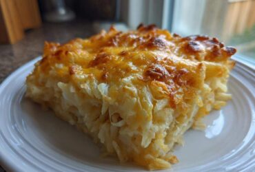 A square slice of golden-brown Copycat Cracker Barrel Hashbrown Casserole with melted, bubbly cheese on top.
