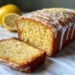 Close-up of a Copycat Starbucks Iced Lemon Loaf, sliced, drizzled with white icing and lemon zest.