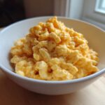 A close-up of creamy, cheesy Instant Pot Mac and Cheese piled high in a white serving bowl.