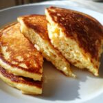 Close-up of fluffy Gluten-Free Buttermilk Pancakes cut to show the airy interior texture.