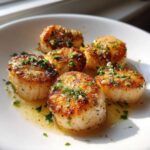 Close-up of six golden-brown Garlic Butter Scallops with Lemon, glistening in butter sauce and topped with fresh parsley.