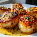 Close-up of perfectly seared Garlic Butter Scallops with Lemon sauce and fresh parsley.