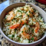 Close-up of Garlic Butter Shrimp and Rice Skillet topped with fresh parsley in a light-colored bowl.