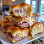 Stack of Hawaiian Roll Ham and Cheese Sliders with melted cheese pulling apart.