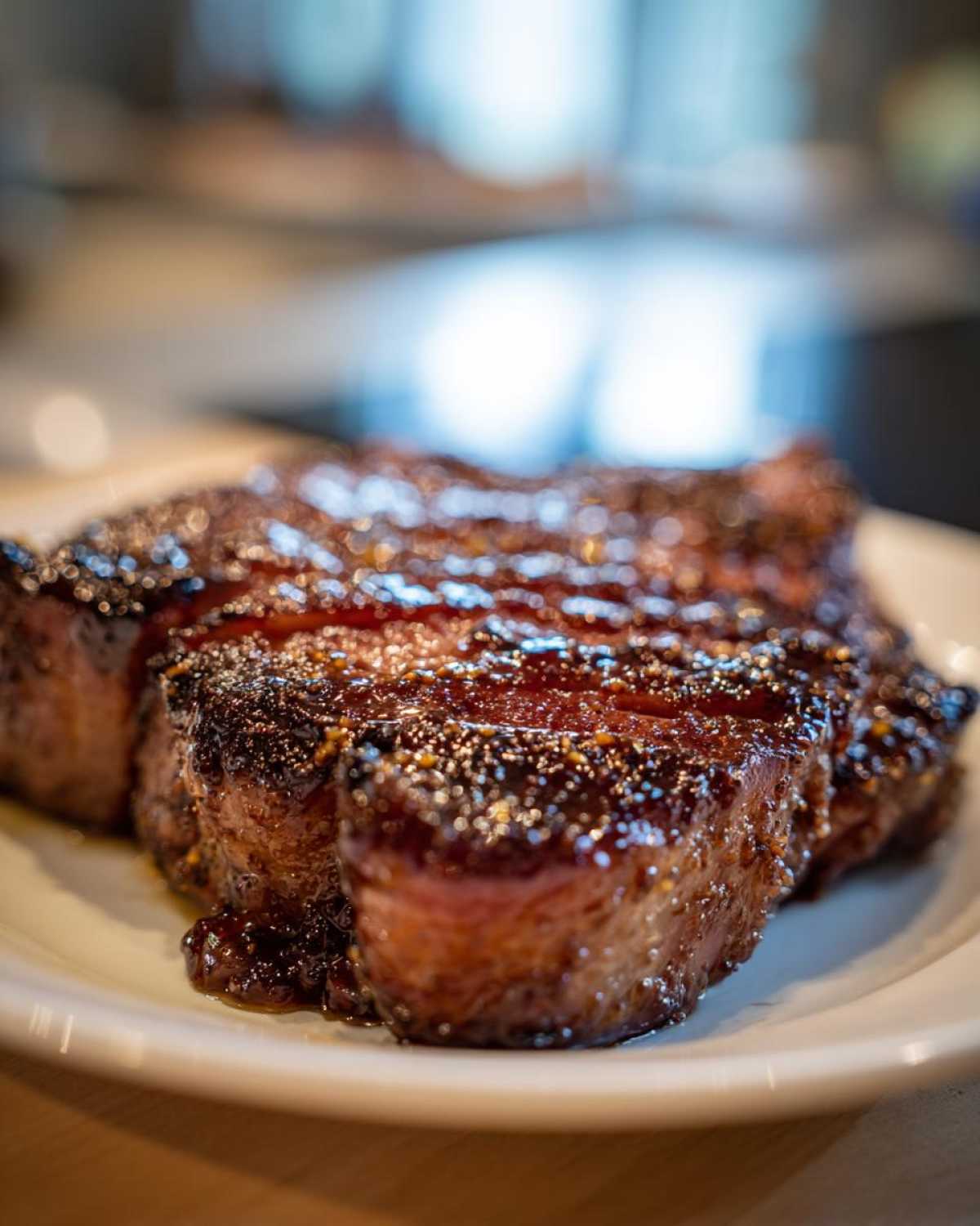 A close-up, appetizing shot of a thick Honey Glazed Ham Steak in the Skillet, glistening with a dark, caramelized glaze.