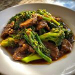 A close-up of tender slices of beef coated in savory sauce mixed with bright green broccoli florets in Instant Pot Beef and Broccoli.