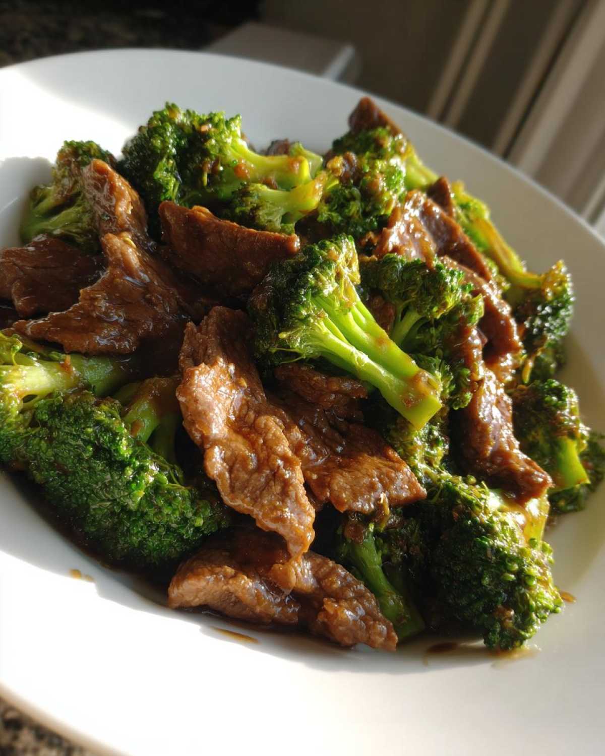 A close-up of tender slices of beef mixed with bright green broccoli florets coated in a savory sauce, ready to eat Instant Pot Beef and Broccoli.