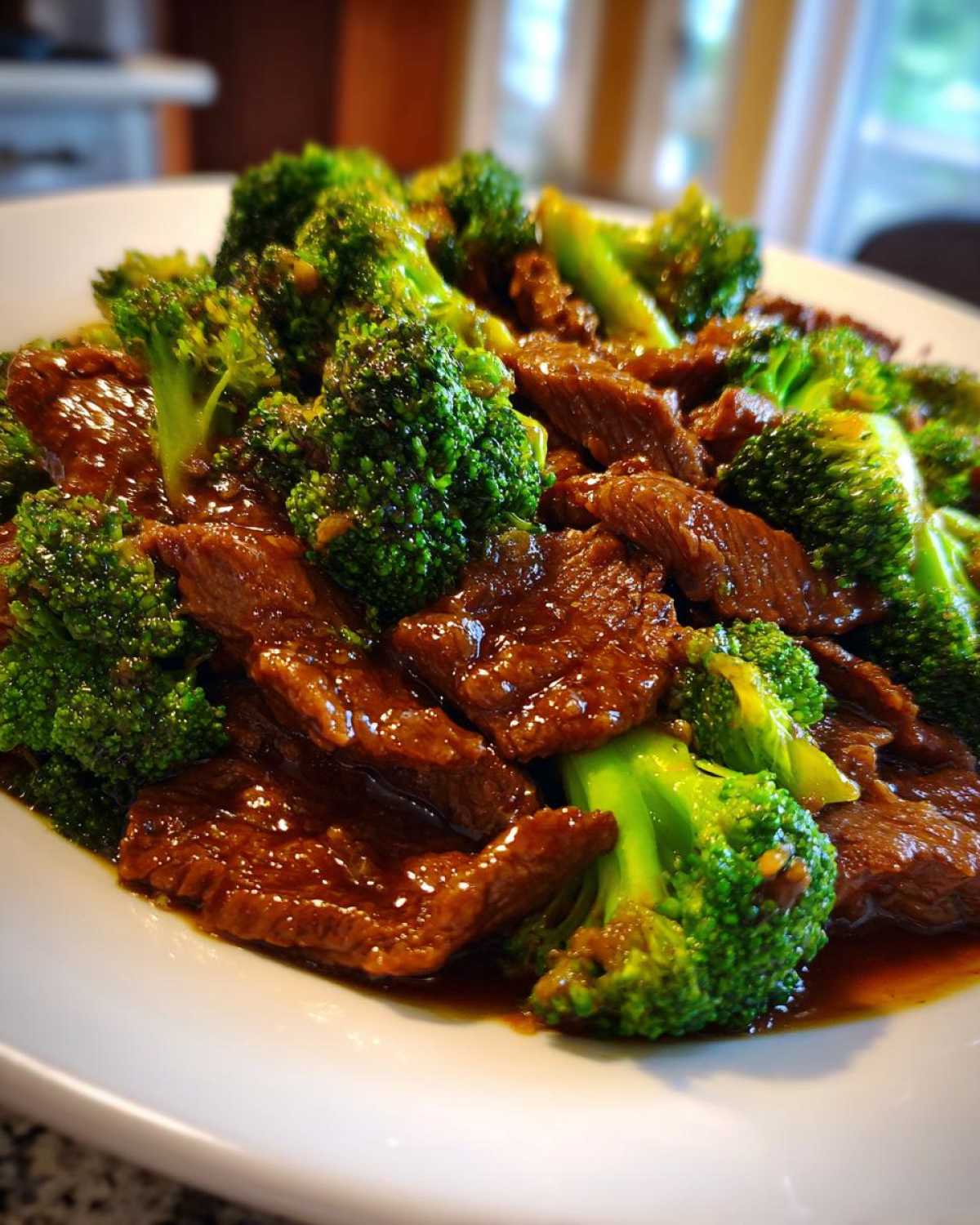 Close-up of tender slices of beef coated in glossy brown sauce mixed with bright green broccoli florets, featuring Instant Pot Beef and Broccoli.