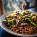 Close-up of steaming One-Pot Beef and Broccoli Ramen Noodles on a white plate.