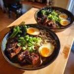 Two bowls of Spicy Miso Ramen featuring soft-boiled eggs, savory meat, and green onions on a wooden surface.