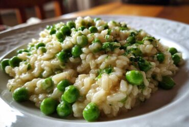 Close-up of creamy Spring Pea and Mint Risotto served on a white plate, garnished with bright green peas and fresh mint.