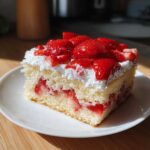 A moist slice of Strawberry Shortcake Sheet Cake topped with whipped cream and fresh, glossy strawberries.