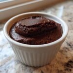 A close-up of rich, dark Vegan Chocolate Avocado Mousse served in a small white fluted ramekin.