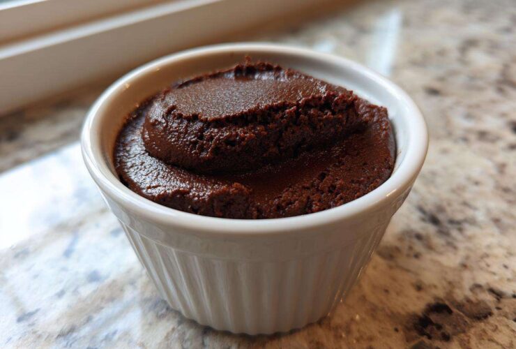 A close-up of rich, dark Vegan Chocolate Avocado Mousse served in a small white fluted ramekin.