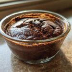 Close-up of thick, dark Vegan Chocolate Chia Pudding set in a small clear glass bowl.